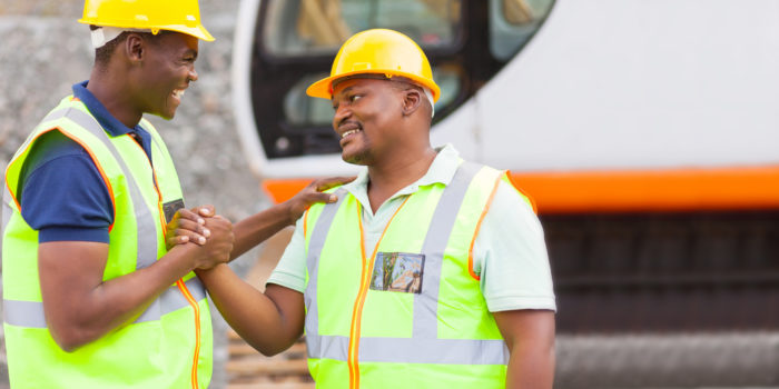cheerful african mine workers hands together to form brotherhood